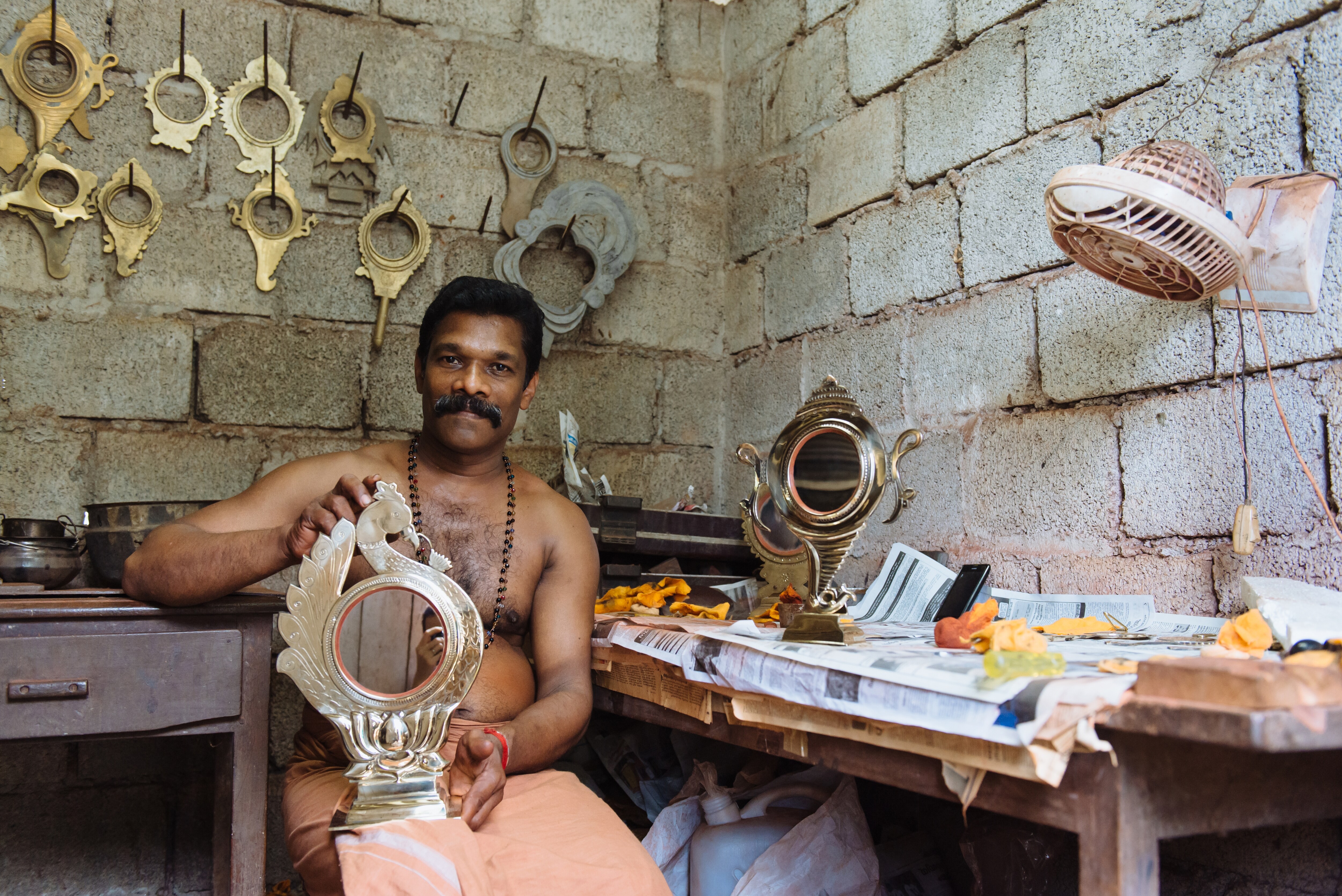 A master craftsman with an Aranmula kannadi, a handmade mirror of metal alloy made in Aranmula, Kerala. (Nina Lishchuk / Shutterstock)