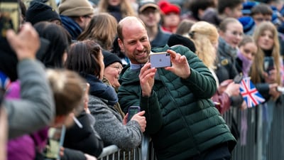 Britain's Prince William takes a selfie with people who have gathered to greet him. (via REUTERS)