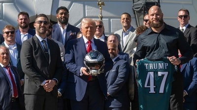 Trump holds up a helmet, flanked by Philadelphia Eagles' tackle #65 Lane Johnson (R) and Philadelphia Eagles head coach Nick Sirianni (L), as he hosts an event celebrating the Philadelphia Eagles, 2025 Super Bowl champions, at the White House on April 28, 2025, in Washington, DC. (AFP) Trump holds up a helmet, flanked by Philadelphia Eagles' tackle #65 Lane Johnson (R) and Philadelphia Eagles head coach Nick Sirianni (L), as he hosts an event celebrating the Philadelphia Eagles, 2025 Super Bowl champions, at the White House on April 28, 2025, in Washington, DC. (AFP)
