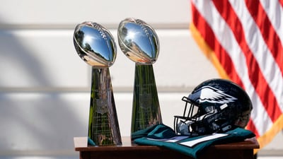 Two Vince Lombardi Trophies, a helmet and jersey on a table before Trump honors the Super Bowl LIX champion Philadelphia Eagles at The White House in Washington D.C., on April 28, 2025. (IMAGN IMAGES via Reuters Connect)