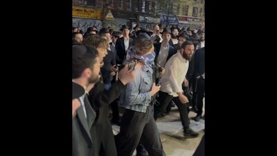 This image taken from video shows a woman and a police officer as they are pursued by a crowd of men in the Crown Heights section of Brooklyn, N.Y., on Thursday, April 24, 2025. (AP Photo) This image taken from video shows a woman and a police officer as they are pursued by a crowd of men in the Crown Heights section of Brooklyn, N.Y., on Thursday, April 24, 2025. (AP Photo)