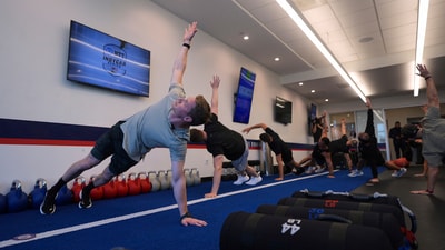 Two-time IndyCar series champion Josef Newgarden, left, leads a group through the paces of his physical workout, a cross-fit session designed to fine-tune the entire body for strength and endurance in racing. (AP Photo/Eric Gay)