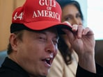 Tesla CEO Elon Musk reacts while wearing a cap with the words "Gulf of America" 