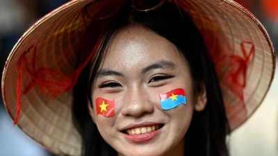 A woman poses wearing stickers of Vietnam's national flag (L) and the Vietnam Liberation Force flag (R) on her face as she takes part in celebrations to mark the 50th anniversary of the fall of Saigon and the end of the Vietnam War in Ho Chi Minh City on April 30, 2025. Vietnam held its biggest celebration of the fall of Saigon on its 50th anniversary on April 30, including Chinese troops for the first time after Xi Jinping visited to portray Beijing as a more reliable partner than Washington. (Photo by MANAN VATSYAYANA / AFP) (AFP) A woman poses wearing stickers of Vietnam's national flag (L) and the Vietnam Liberation Force flag (R) on her face as she takes part in celebrations to mark the 50th anniversary of the fall of Saigon and the end of the Vietnam War in Ho Chi Minh City on April 30, 2025. Vietnam held its biggest celebration of the fall of Saigon on its 50th anniversary on April 30, including Chinese troops for the first time after Xi Jinping visited to portray Beijing as a more reliable partner than Washington. (Photo by MANAN VATSYAYANA / AFP) (AFP)