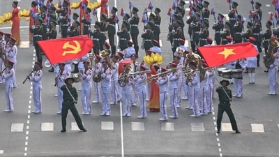 Participants wave flags next to a marching band during a parade marking the 50th anniversary of the fall of Saigon and the end of the Vietnam War in Ho Chi Minh City on April 30, 2025. Vietnam held its biggest celebration of the fall of Saigon on its 50th anniversary on April 30, including Chinese troops for the first time after Xi Jinping visited to portray Beijing as a more reliable partner than Washington. (Photo by NHAC NGUYEN / AFP) (AFP) Participants wave flags next to a marching band during a parade marking the 50th anniversary of the fall of Saigon and the end of the Vietnam War in Ho Chi Minh City on April 30, 2025. Vietnam held its biggest celebration of the fall of Saigon on its 50th anniversary on April 30, including Chinese troops for the first time after Xi Jinping visited to portray Beijing as a more reliable partner than Washington. (Photo by NHAC NGUYEN / AFP) (AFP)