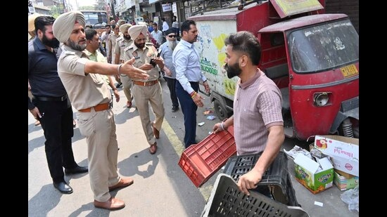 Police personnel removing the illegal encroachment from the Field Ganj in Ludhiana on Wednesday. (HT Photo)