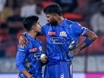 Mumbai Indians' captain Hardik Pandya (R) speaks with Vignesh Puthur
