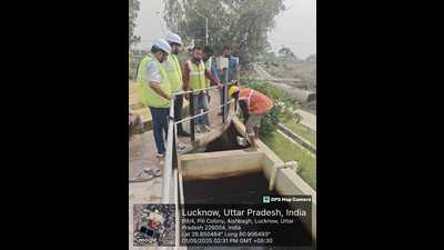Jalkal department officials carrying out cleaning work at the Aishbagh water treatment plant. (HT photo)