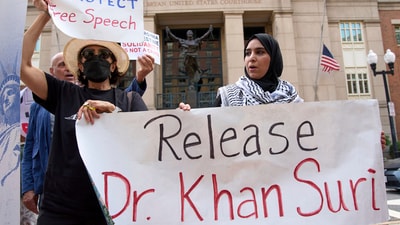 Mapheze Saleh, right, wife of arrested and detained Georgetown University scholar Badar Khan Suri, holds a sign calling for her husband's release (AP) Mapheze Saleh, right, wife of arrested and detained Georgetown University scholar Badar Khan Suri, holds a sign calling for her husband's release (AP)