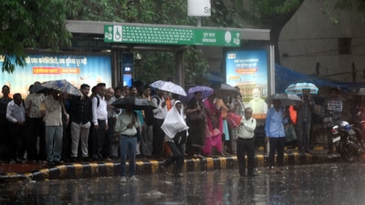 Taking cover under umbrellas, Delhiites wait for their bus during heavy rain at Connaught place in New Delhi on Friday (Arvind Yadav/HT) Taking cover under umbrellas, Delhiites wait for their bus during heavy rain at Connaught place in New Delhi on Friday (Arvind Yadav/HT)