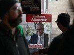A poster of Australia's Prime Minister Anthony Albanese is displayed as people wait to vote in Australia's general election at a polling station in the suburb of Marrickville in Sydney on May 3, 2025. Australians started voting on May 3 in a bitterly contested general election, deciding a contest shaped by living costs, climate anxiety and Trump tariffs. A poster of Australia's Prime Minister Anthony Albanese is displayed as people wait to vote in Australia's general election at a polling station in the suburb of Marrickville in Sydney on May 3, 2025. Australians started voting on May 3 in a bitterly contested general election, deciding a contest shaped by living costs, climate anxiety and Trump tariffs.