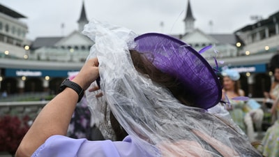A person uses plastic in an attempt to stay dry during a drizzle at Churchill Downs before the 151st running of the Kentucky Derby horse race Saturday, May 3, 2025, in Louisville, Ky. (AP Photo/Jon Cherry) (AP) A person uses plastic in an attempt to stay dry during a drizzle at Churchill Downs before the 151st running of the Kentucky Derby horse race Saturday, May 3, 2025, in Louisville, Ky. (AP Photo/Jon Cherry) (AP)