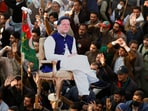Supporters of the former Pakistani Prime Minister Imran Khan's party, the Pakistan Tehreek-e-Insaf (PTI), carry a cutout of him during a protest.
