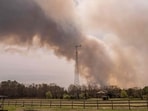 FORKED RIVER, NEW JERSEY - APRIL 24: A wildfire burns in the distance behind Argos Farm on April 24, 2025, in Forked River, New Jersey. (Photo by Adam Gray / GETTY IMAGES NORTH AMERICA / Getty Images via AFP) FORKED RIVER, NEW JERSEY - APRIL 24: A wildfire burns in the distance behind Argos Farm on April 24, 2025, in Forked River, New Jersey. (Photo by Adam Gray / GETTY IMAGES NORTH AMERICA / Getty Images via AFP)