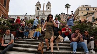 A woman walks her dogs down the Spanish Steps ahead of the conclave to elect the next pope, in Rome, Italy, May 4, 2025. REUTERS/Kevin Coombs (REUTERS)