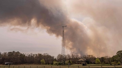 FORKED RIVER, NEW JERSEY - APRIL 24: A wildfire burns in the distance behind Argos Farm on April 24, 2025, in Forked River, New Jersey. (Photo by Adam Gray / GETTY IMAGES NORTH AMERICA / Getty Images via AFP) (Getty Images via AFP) FORKED RIVER, NEW JERSEY - APRIL 24: A wildfire burns in the distance behind Argos Farm on April 24, 2025, in Forked River, New Jersey. (Photo by Adam Gray / GETTY IMAGES NORTH AMERICA / Getty Images via AFP) (Getty Images via AFP)