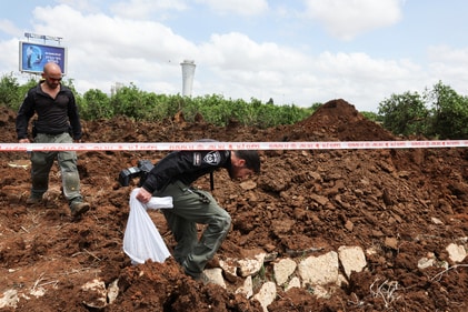 Israeli police officers investigate a crater at the site of a missile attack, launched from Yemen, near Ben Gurion Airport, in Tel Aviv, Israel May 4, 2025. (Reuters)