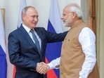 Prime Minister Narendra Modi shakes hands with Russian President Vladimir Putin.