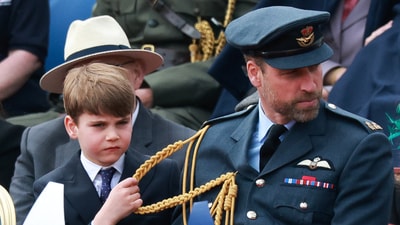 Prince Louis (center) cleans off William, Prince of Wales as his dad explains him parade during the military procession for the 80th anniversary of V-E Day at Buckingham Palace. (REUTERS)