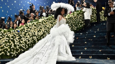 Diana Ross's 18-foot train, feathery shawl, floor-length silver gown, and this eye-catching, feathered headpiece attracted attention and added drama.&nbsp; (Evan Agostini/Invision/AP)