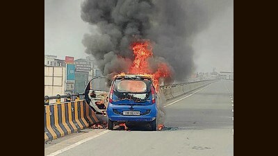 The Tata Nano car ablaze on the Zirakpur flyover on the Chandigarh-Ambala highway on Tuesday. (HT Photo)