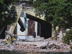 A private security guard walks through rubble of a damaged building after an Indian missile attack in Muridke. A private security guard walks through rubble of a damaged building after an Indian missile attack in Muridke.