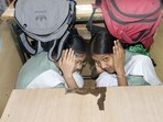School students take shelter under a bench during a mock drill at Nagar Nigam Balika Inter College in Ghaziabad.
