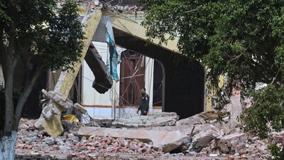 A private security guard walks through rubble of a damaged building after an Indian missile attack in Muridke. (AP) A private security guard walks through rubble of a damaged building after an Indian missile attack in Muridke. (AP)