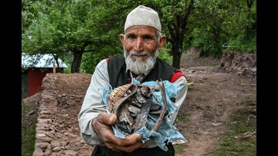 Mohammad Nazir Khan, a Kashmiri resident, holds splinters of a mortar shell that exploded near his house in Kalgi village in Uri, about 125kms from Srinagar on Thursday. (AFP)