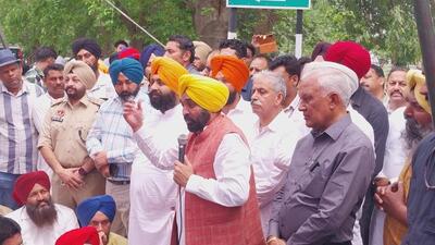 Punjab chief minister Bhagwant Mann addressing Aam Aadmi Party workers, while state education minister Harjot Singh Bains looks on after locking the the Nangal dam guest house gate during BBMB chairman Manoj Tripathi’s visit on Thursday. (HT Photo)