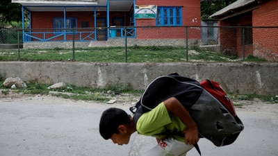 A boy walks past a school after schools remained closed for the second day following clashes between India and Pakistan, in Srinagar on May 8, 2025. (REUTERS)