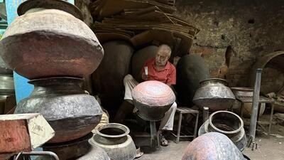 Ramesh Chandra hammers at a huge brass cauldron. (HT Photo) Ramesh Chandra hammers at a huge brass cauldron. (HT Photo)