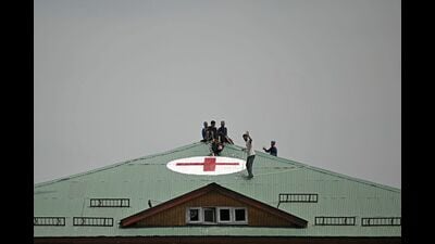Workers paint a red cross symbol over the roof of a hospital in Srinagar amid tension along the border. (AFP) Workers paint a red cross symbol over the roof of a hospital in Srinagar amid tension along the border. (AFP)
