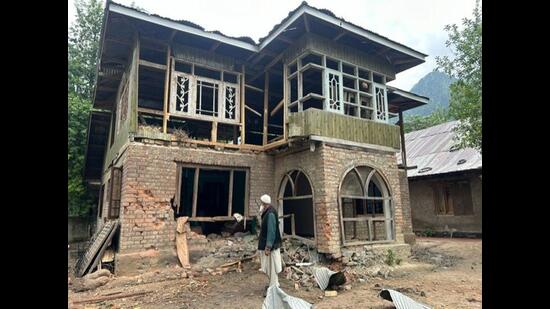 A man standing near a damaged house after shelling by Pakistani troops in the Gingle area of Uri in Baramulla district on Friday. (Waseem Andrabi/HT)