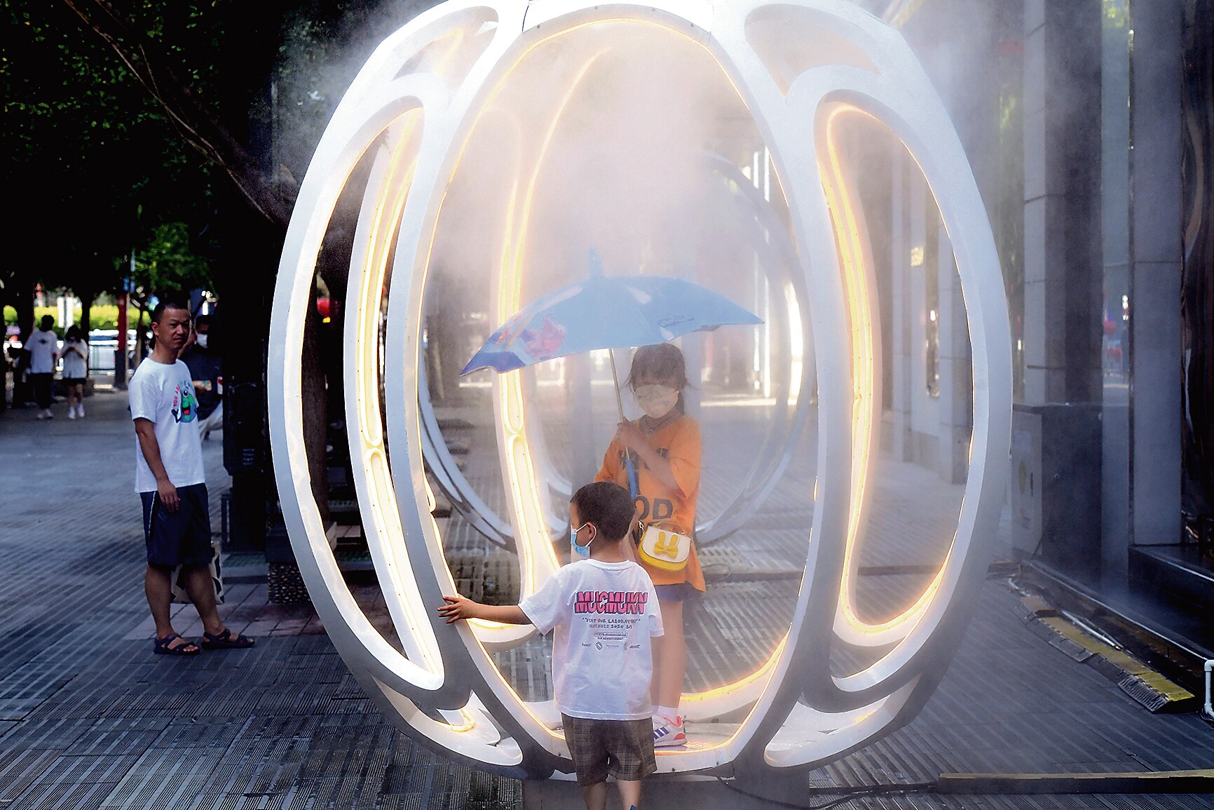 A family at a misting spot in China, amid the 2022 heatwave. (Getty Images) A family at a misting spot in China, amid the 2022 heatwave. (Getty Images)