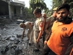 Security personnel investigate at the site of a damaged house following an attack from Pakistan near Aap Shambhu Mandir in Jammu on Saturday, 
