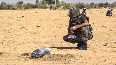 A security person inspecting the debris of a projectile in Rajasthan’s Jaisalmer. (PTI) A security person inspecting the debris of a projectile in Rajasthan’s Jaisalmer. (PTI)