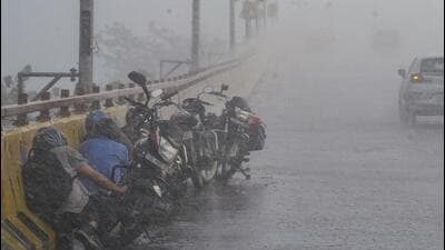 Bikers take cover on the side of a road amid heavy rainfall in Ghaziabad on May 8. (PTI Photo) Bikers take cover on the side of a road amid heavy rainfall in Ghaziabad on May 8. (PTI Photo)