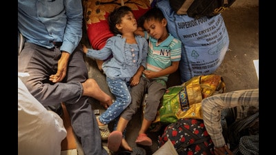 The children of a migrant family sleep on a platform as they wait to board a train at a railway station in Jammu. (REUTERS) The children of a migrant family sleep on a platform as they wait to board a train at a railway station in Jammu. (REUTERS)