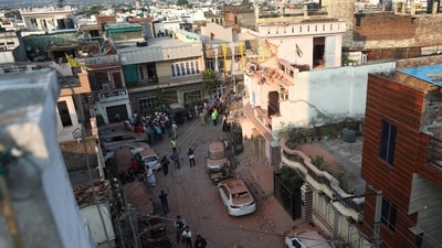 People gather near houses and vehicles damaged due to an attack from Pakistan, in Jammu, on Saturday, May 10, 2025. (PTI)