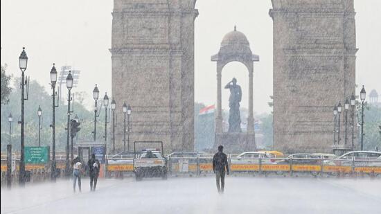 People caught in the rain at Kartavya Path in Delhi on Saturday. (Vipin Kumar/HT Photo)