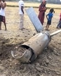 People gather near the debris of an unidentified projectile which landed amid the military conflict between India and Pakistan, in Sirsa, Haryana on Saturday (PTI)