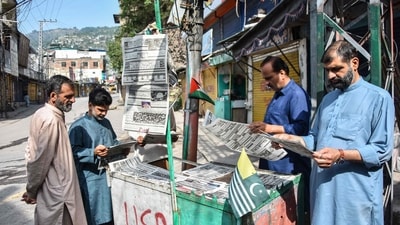 Residents read morning Urdu newspapers with the headline 'The ceasefire between Pakistan and India' on a roadside in Muzaffarabad of Pakistan-administered Kashmir, on May 11, 2025. (AFP) Residents read morning Urdu newspapers with the headline 'The ceasefire between Pakistan and India' on a roadside in Muzaffarabad of Pakistan-administered Kashmir, on May 11, 2025. (AFP)