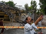 A man takes a picture in front of the wreckage of a restaurant's shade outside the Rawalpindi cricket stadium after an alleged drone was shot down in Rawalpindi on May 8.