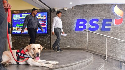 A security personnel with a sniffer dog keeps vigil as people walk out of the Bombay Stock Exchange building in Mumbai. (PTI) A security personnel with a sniffer dog keeps vigil as people walk out of the Bombay Stock Exchange building in Mumbai. (PTI)