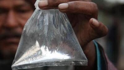 A man shows a packet of illicit liquor. (HT File Photo)