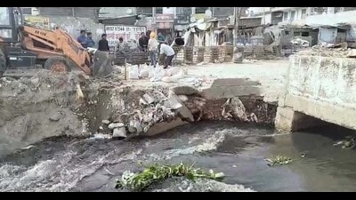 Repair works underway on the road that collapsed near New Kundanpuri on Monday. (HT Photo)