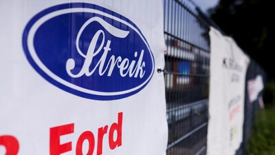 The word "Strike" is displayed in the typography of Ford logo on a banner, as workers rally during a strike by IG Metall union at a Ford plant in Cologne, Germany, May 14, 2025. (REUTERS)