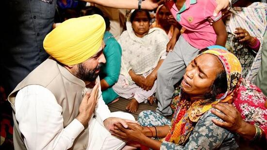 Punjab chief minister Bhagwant Mann consoling family members of the hooch tragedy victims at Majitha in Amritsar on Tuesday. (Sameer Sehgal/HT)