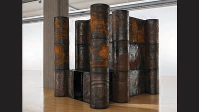 For Darkroom (2006), Sheela Gowda stacked tar drums to create a hut like those found in Indian slums. For Darkroom (2006), Sheela Gowda stacked tar drums to create a hut like those found in Indian slums.